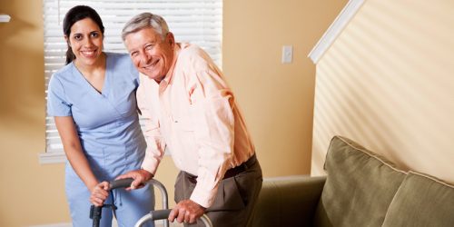 Caregiver assisting older man.