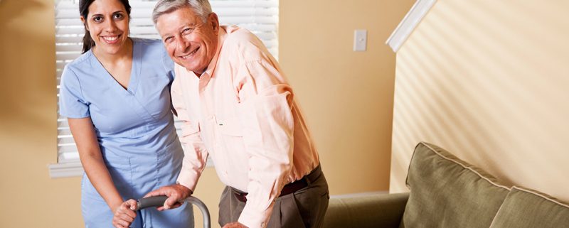 Caregiver assisting older man.