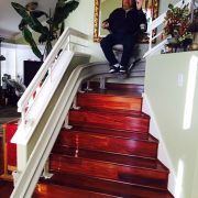 Client Fabricante descending seated in stairlift.